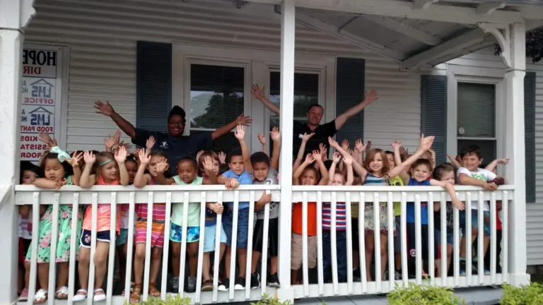 children-raising-arms-on-porch